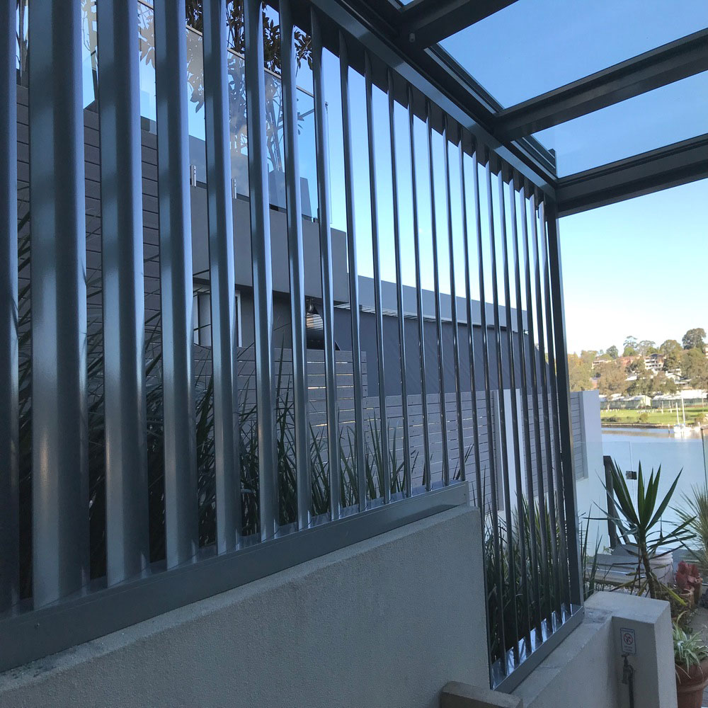 160mm vertical aluminium louvres installed on the side of a balcony with a step-down, used as a privacy screen.
