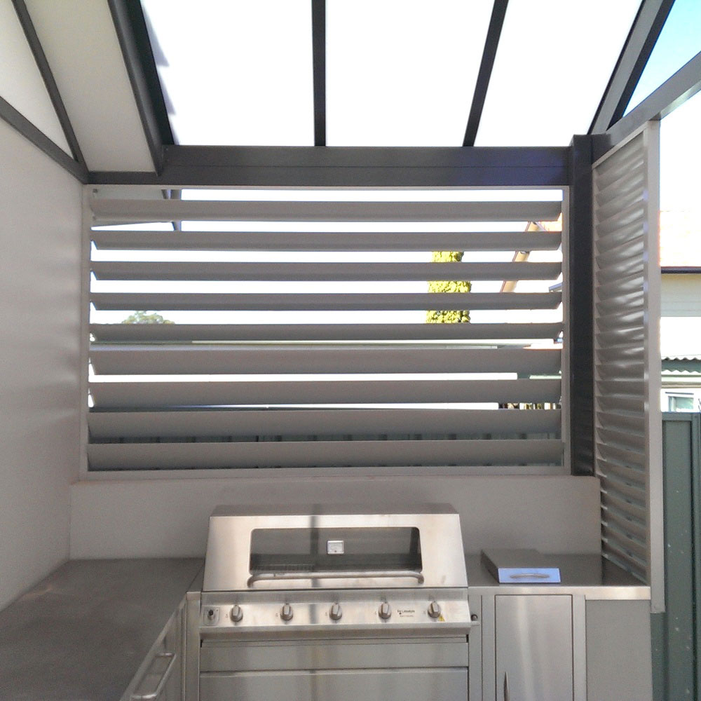 Horizontal 160mm adjustable louvres installed behind an outdoor barbecue area for ventilation and privacy.