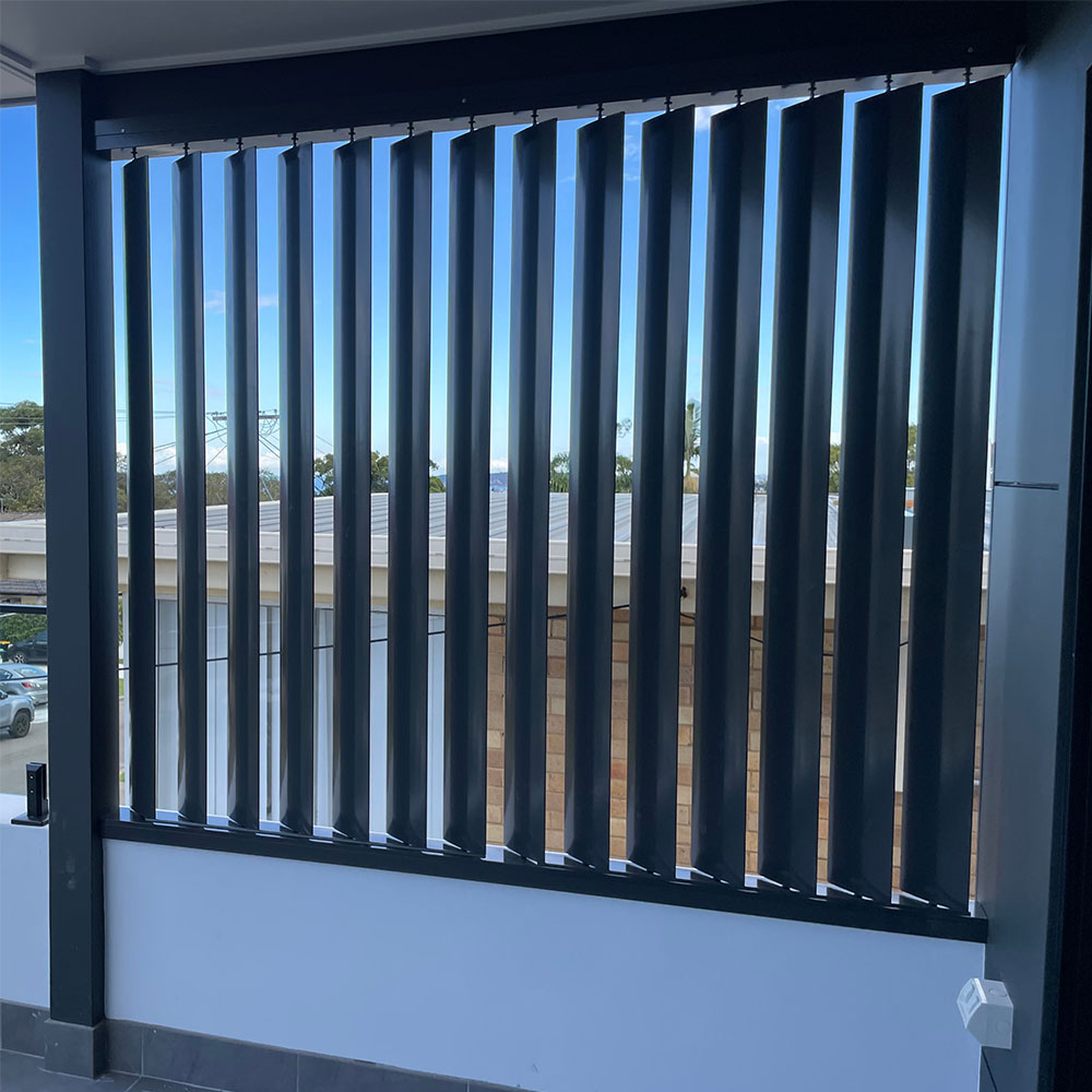 Vertical 160mm aluminium louvres installed on the side of a verandah for privacy and sun control.