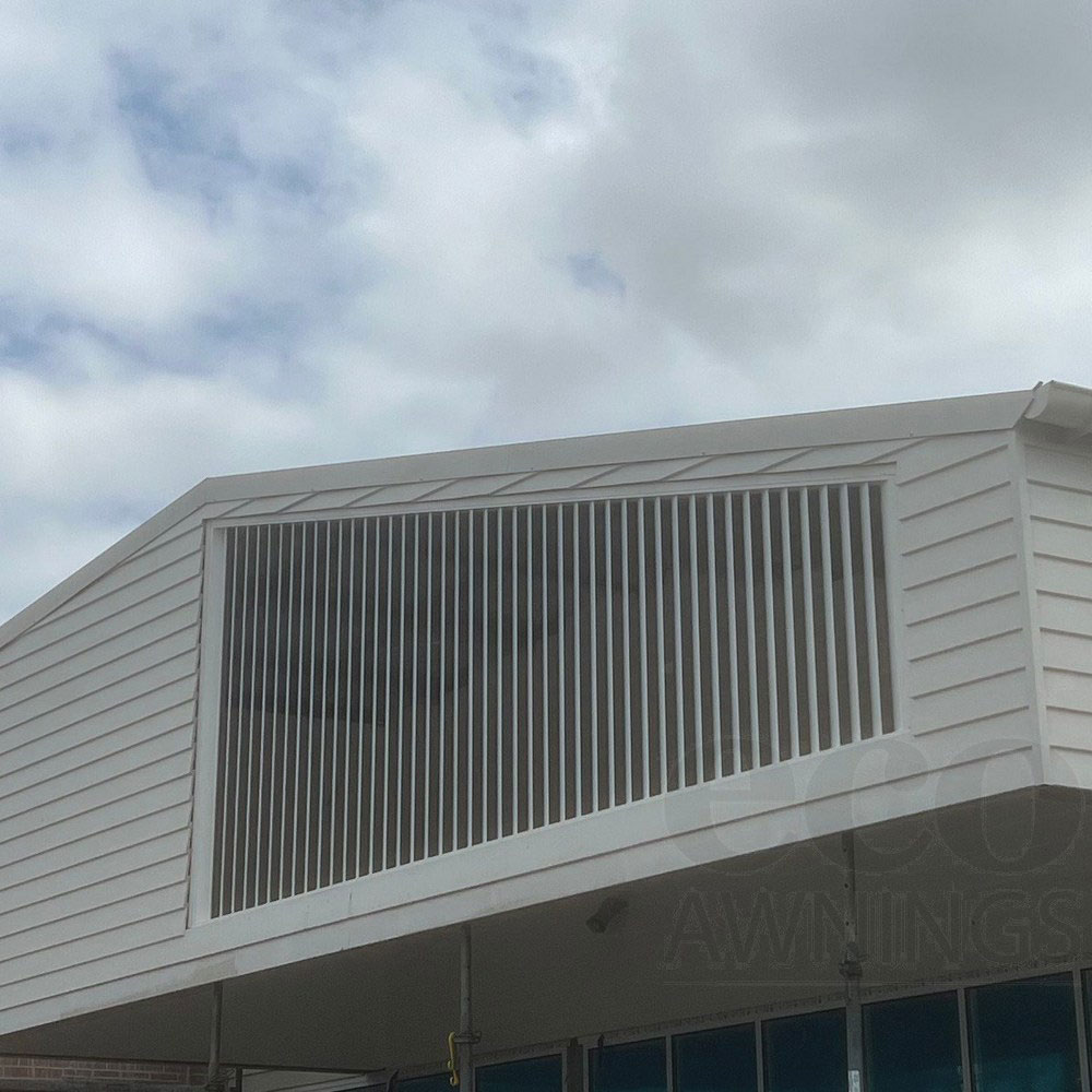 Angled 160mm fixed aluminium louvres following the side of a gable to enclose an internal patio.