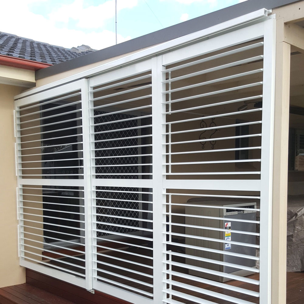 85mm adjustable aluminium louvres in the fully open position, sliding along the side of a balcony to provide airflow and visibility.