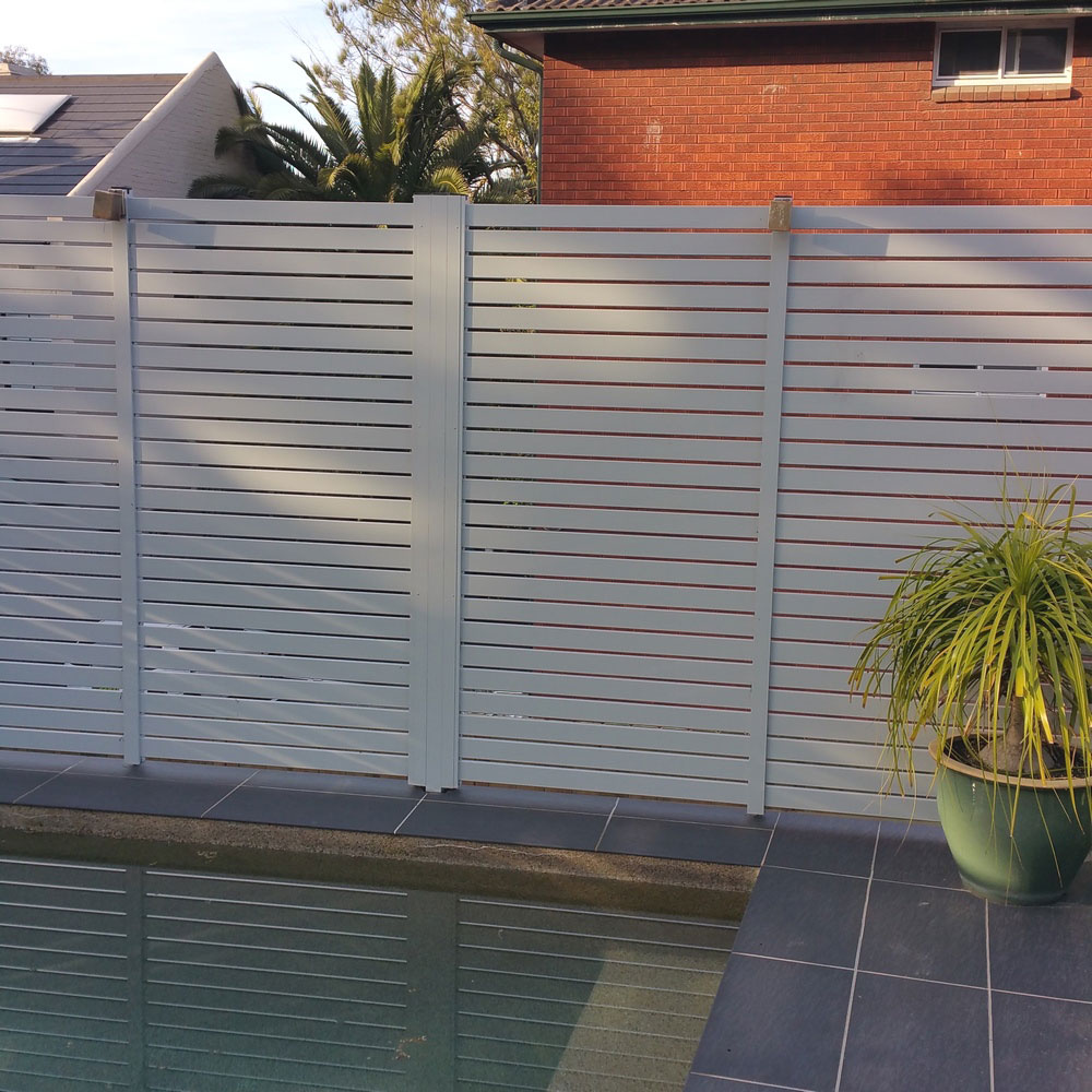 Aluminium slat fence installed around the perimeter of a pool to provide privacy and a modern, streamlined appearance.