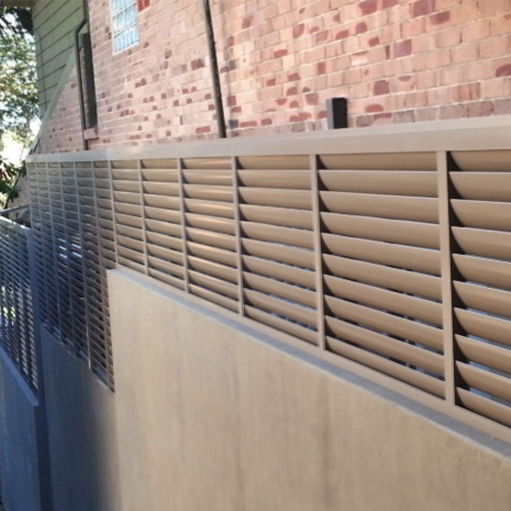 85mm fixed louvres used as a privacy screen fence between two buildings, viewed from an angled perspective.