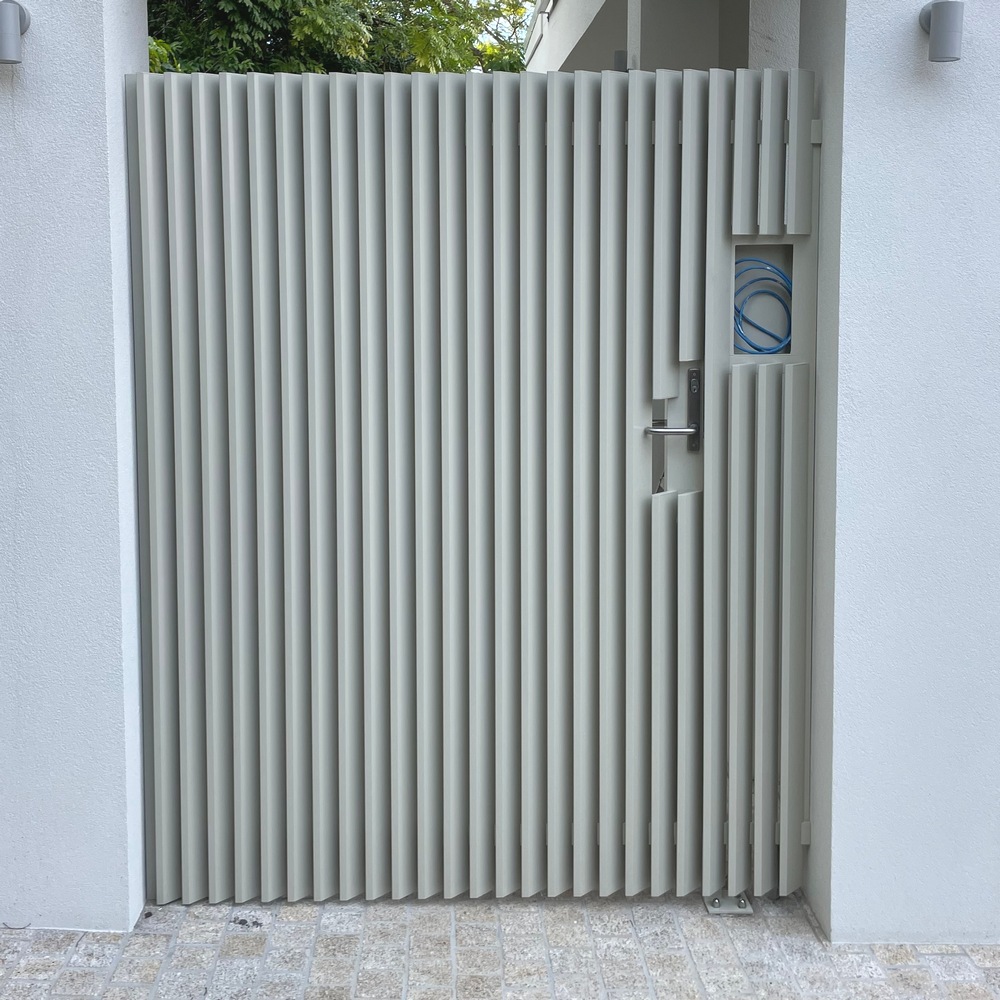 Vertical angled aluminium slat gate shown from front elevation in unit walkway