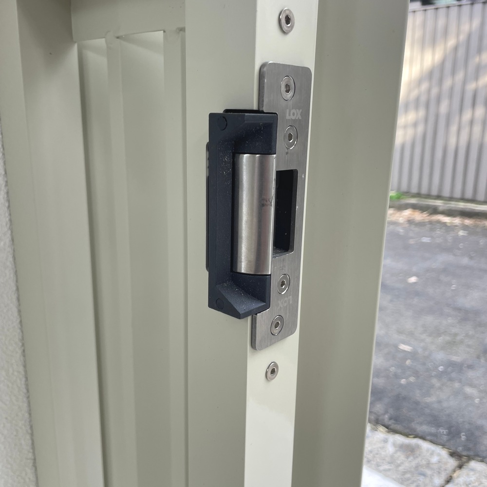 Electric striker fitted to vertical angled aluminium slat gate with side panel