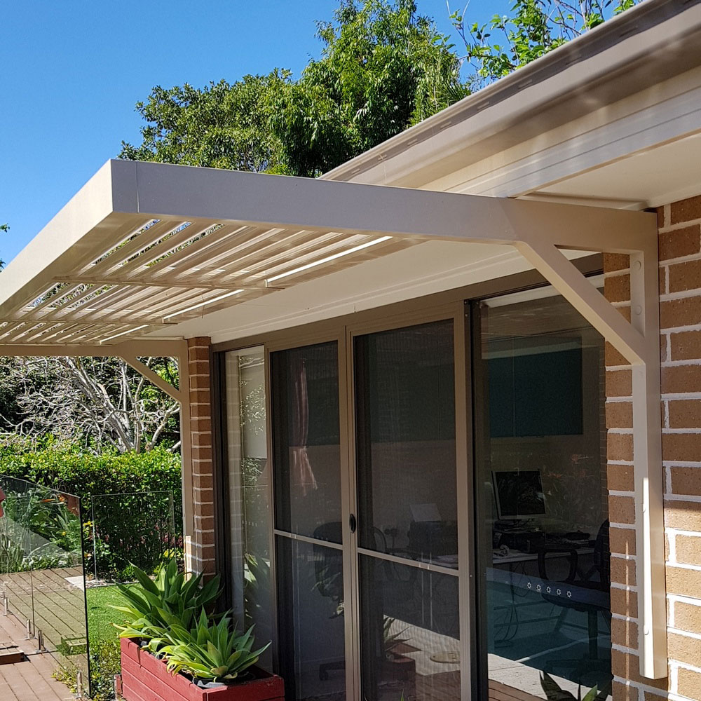 Cantilever aluminium louvre awning with 85mm blades installed under an eave above sliding doors in a modern Sydney home.