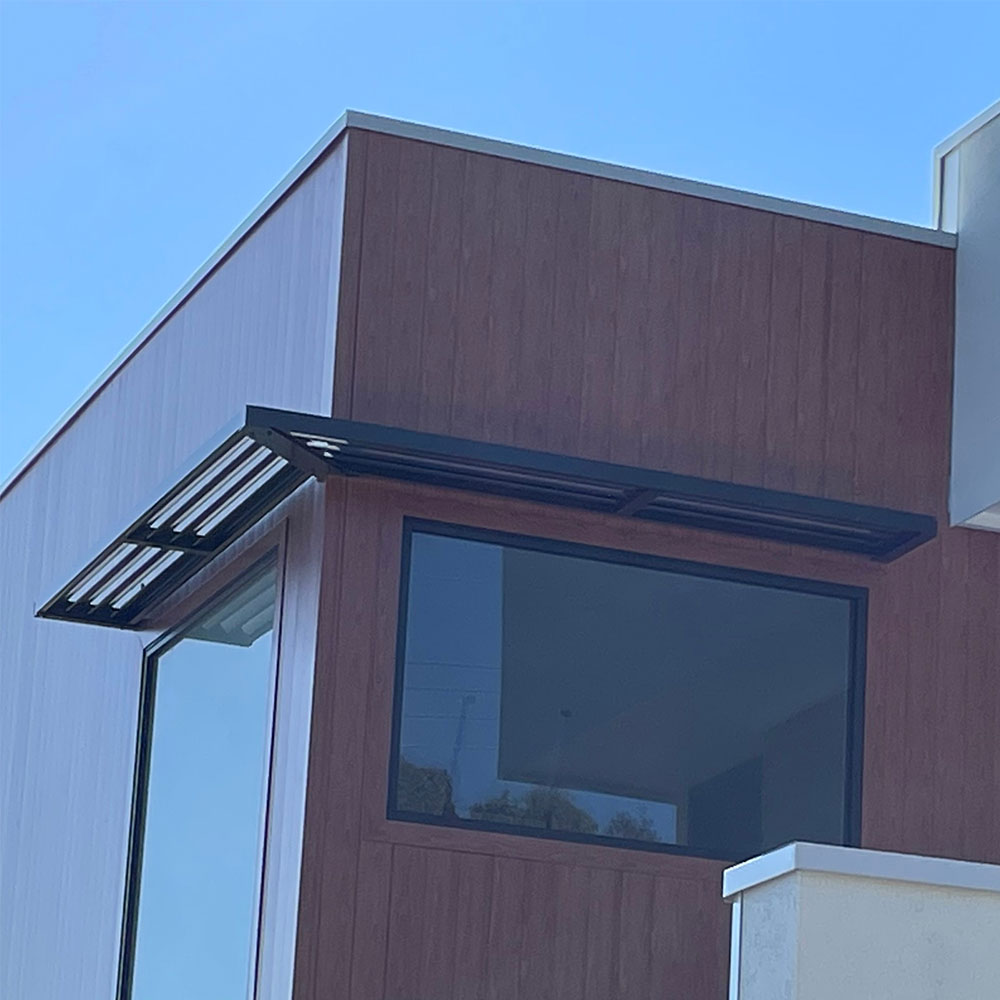 Cantilever aluminium louvre awning wrapping around a corner window on a modern home in Sydney