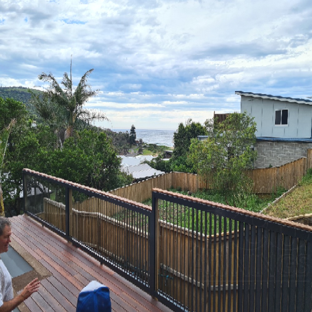 160mm adjustable aluminium louvres installed as a balcony privacy screen with vertical posts and ocean outlook