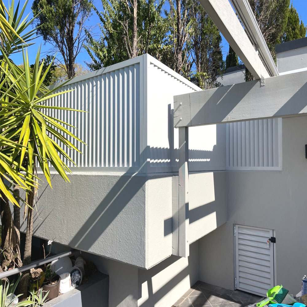 Vertical 85mm aluminium louvres installed on top of a boundary wall to provide privacy.